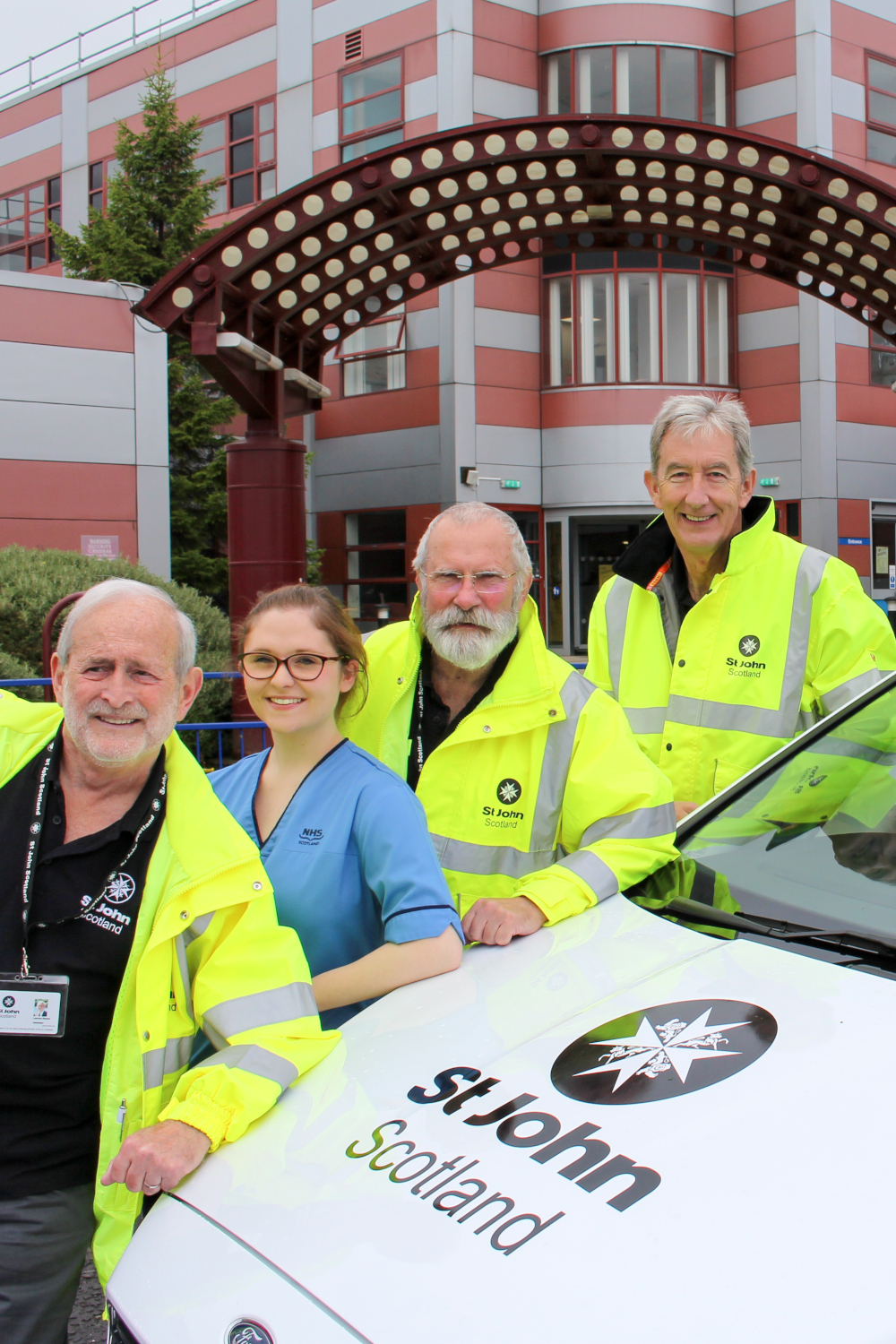 Photo of volunteers with a St John Vehicle