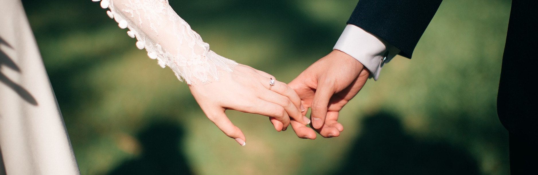 Photo of a bride and groom holding hands 