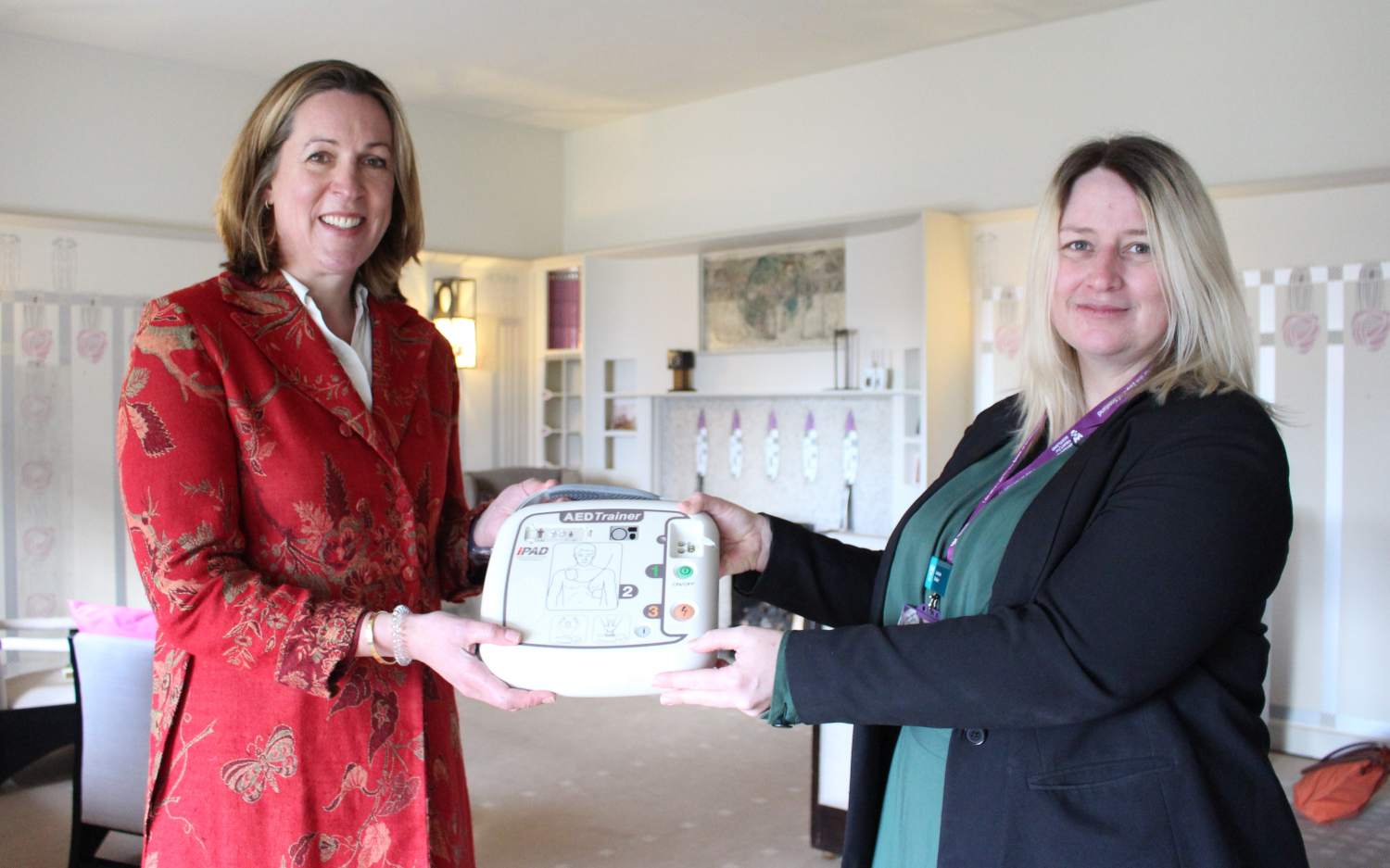 Two women pose with a defibrillator