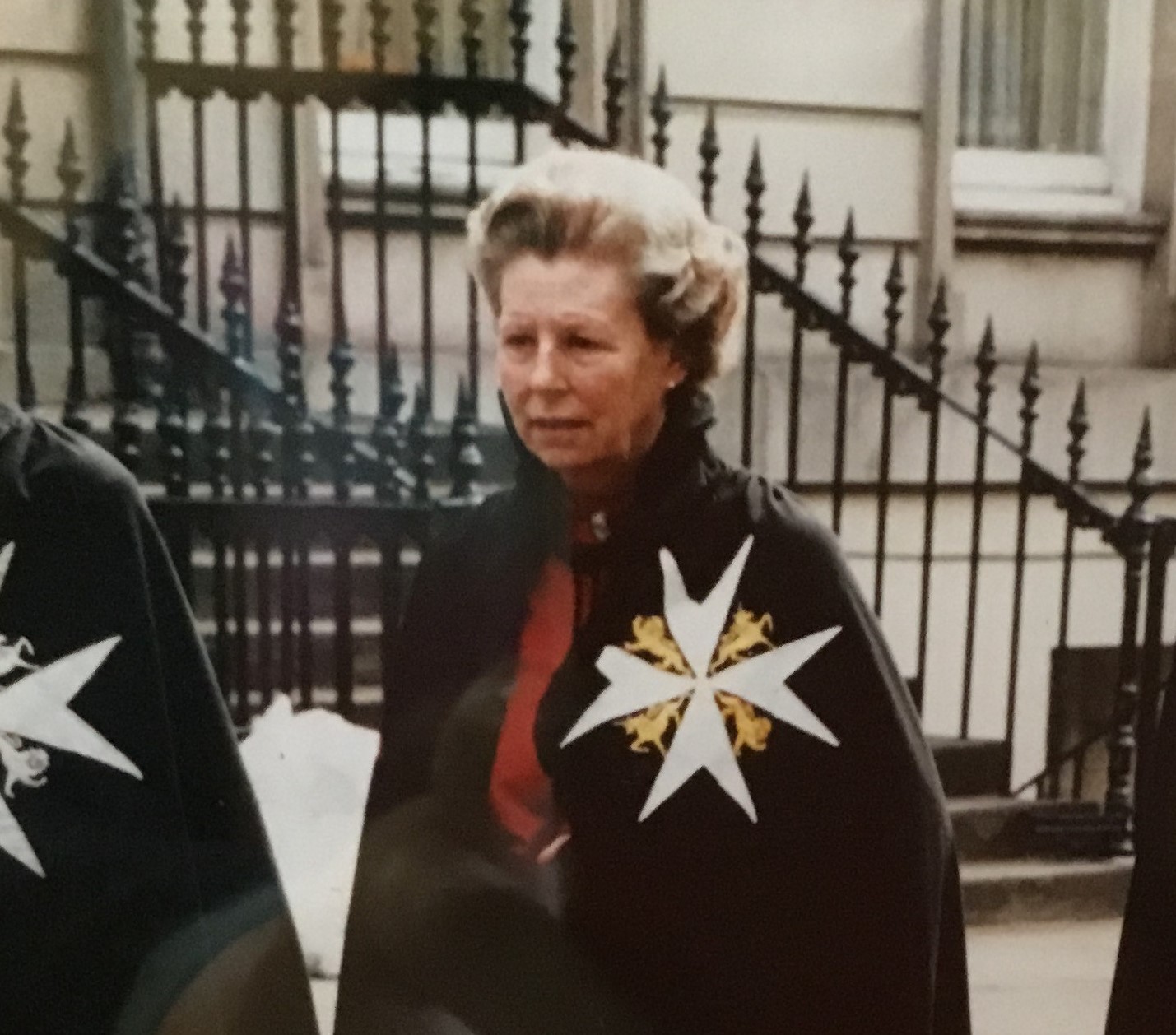 A woman wearing an Order of St John mantle