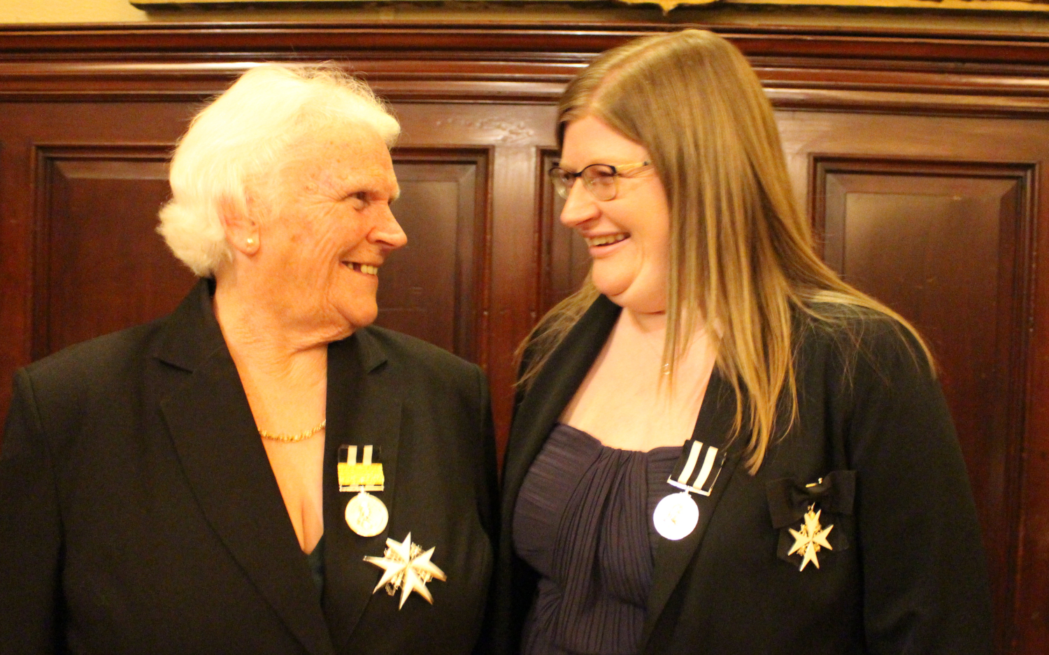 Two women smile at each other