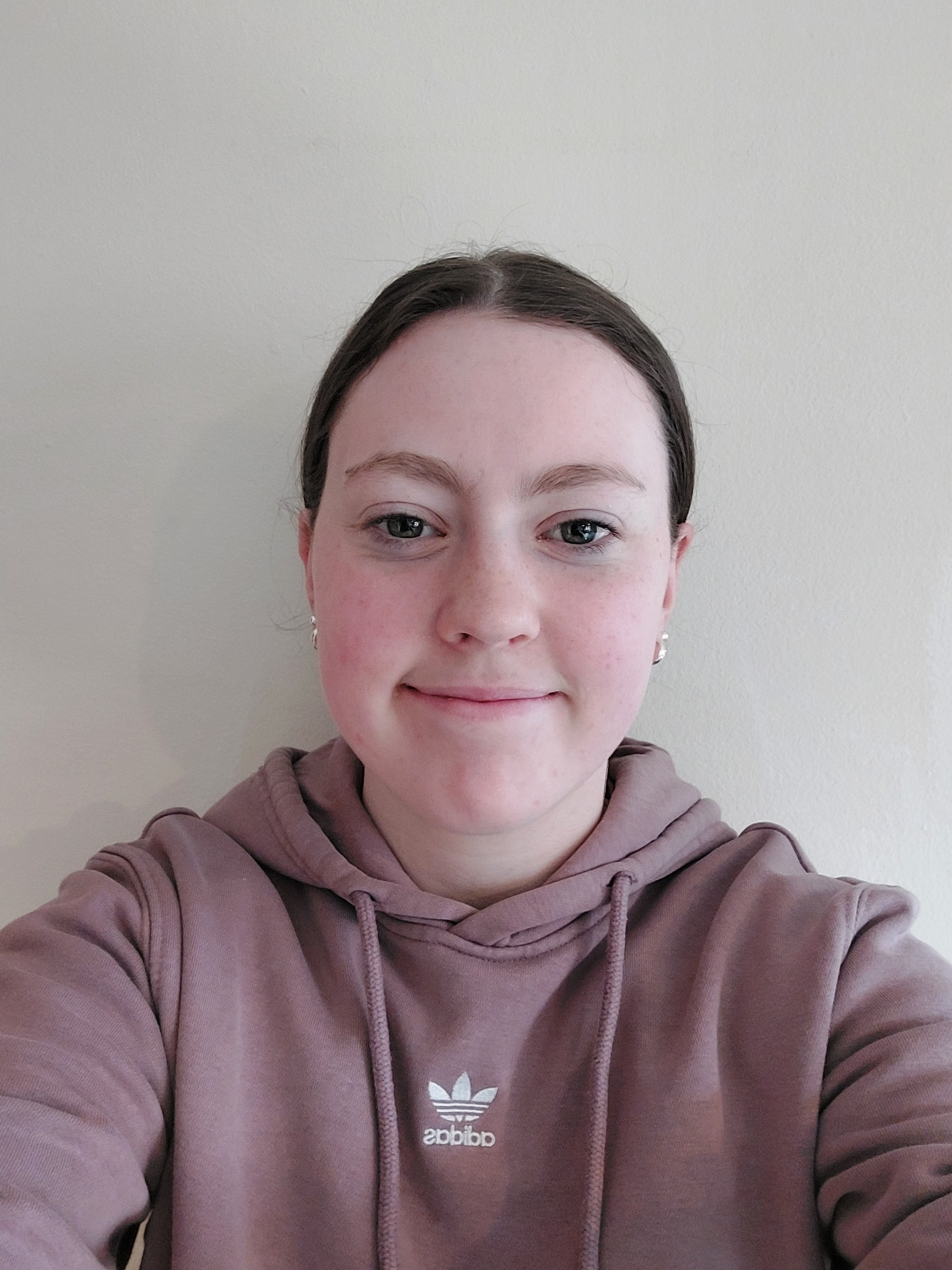 A woman in a purple hoodie against a white backdrop