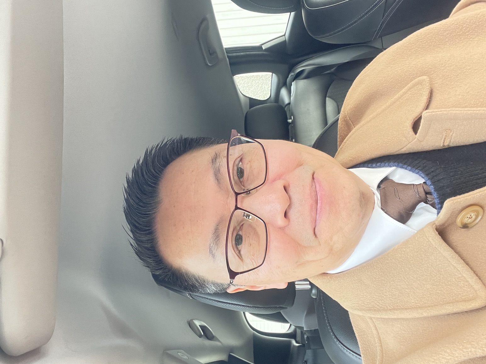 A man with glasses in a car